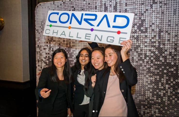 girls holding conrad sign