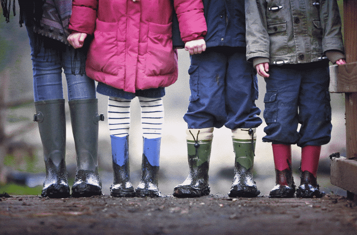 Alt Text: children in rain boots gifted children
