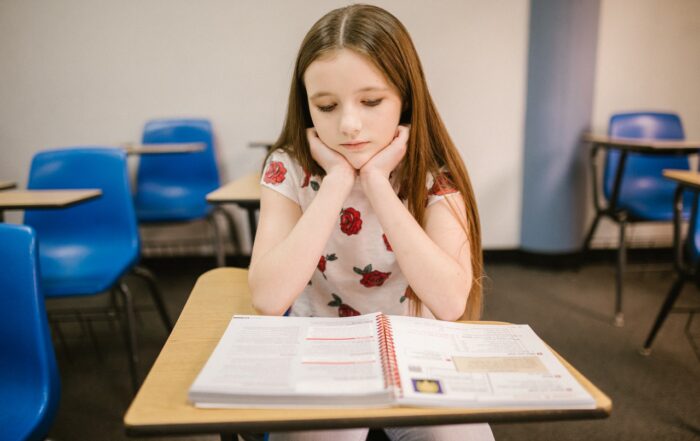 young girl sitting in class reading