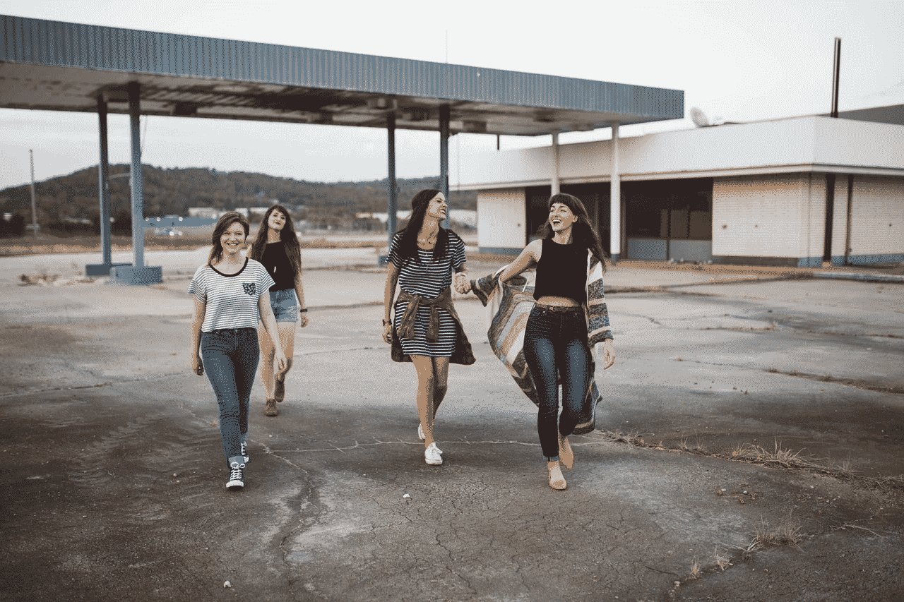four girls walking and smiling