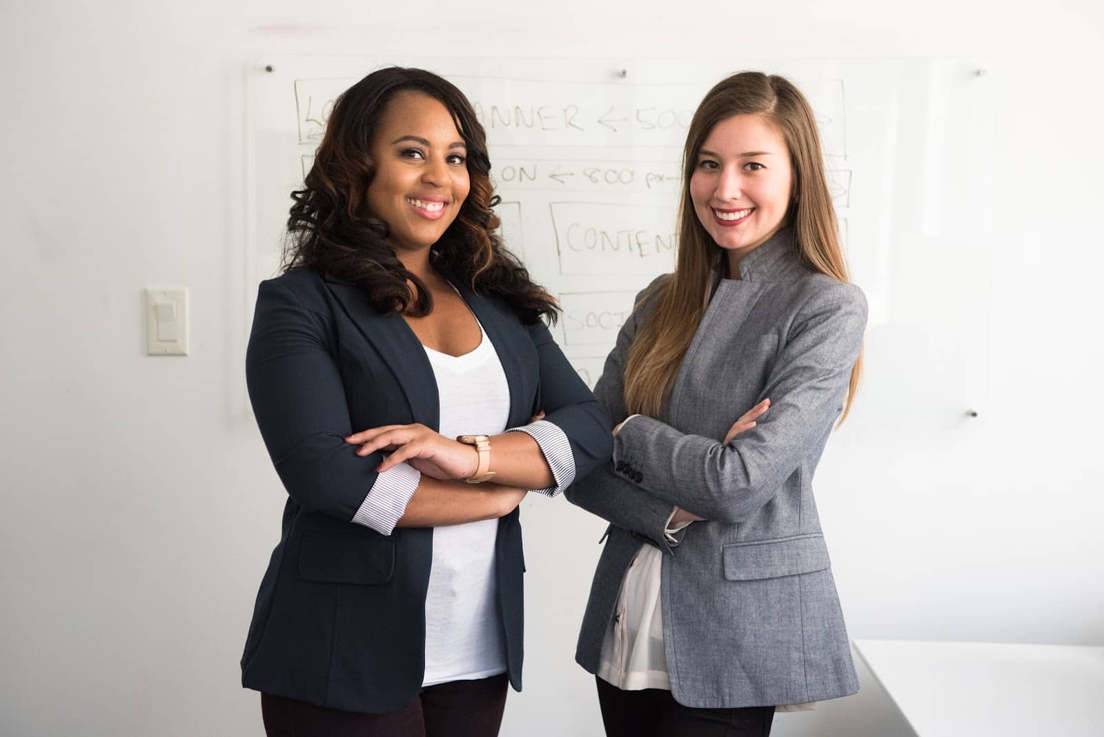 Two young women folded arms