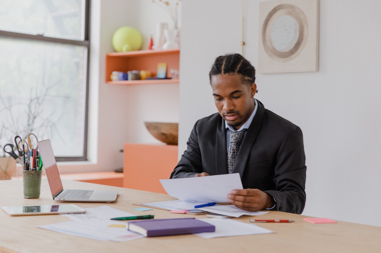 Man Reading Documents while Sitting in Office