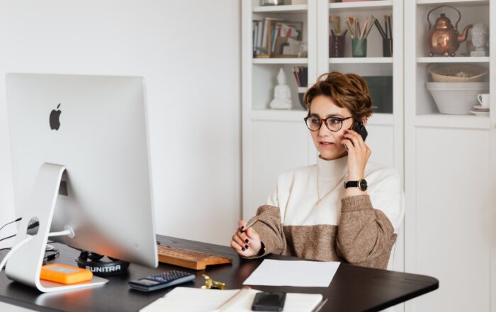 Serious female executive communicating on mobile phone in cozy office