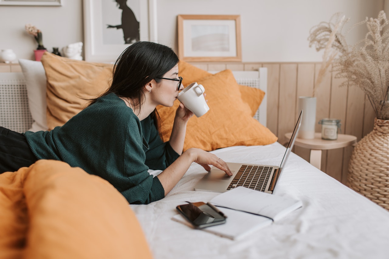 teenager reading a book on her bed 