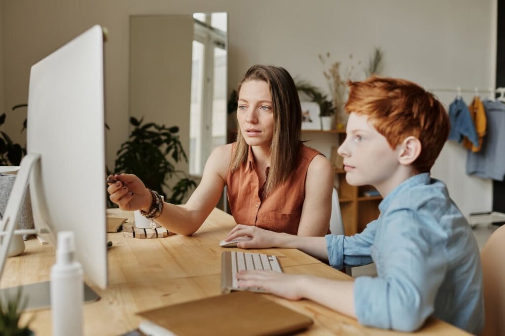 Photo of teacher and a student working on a computer