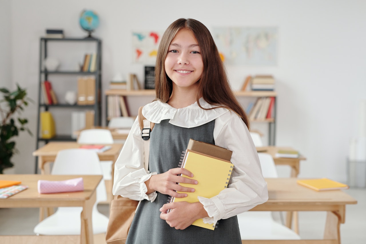 young middle school student holding a notepad